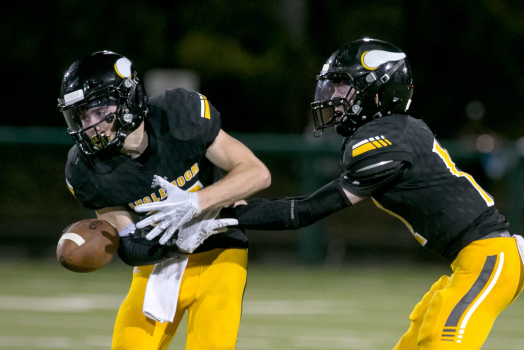 Inglemoor’s Jake Dick (left) fumbles the handoff from Inglemoor’s Mack Heaton Thursday night at Pop Kenney Stadium in Bothell on August 30, 2018. Inglemoor won 29-28. (Kevin Clark / The Herald)
