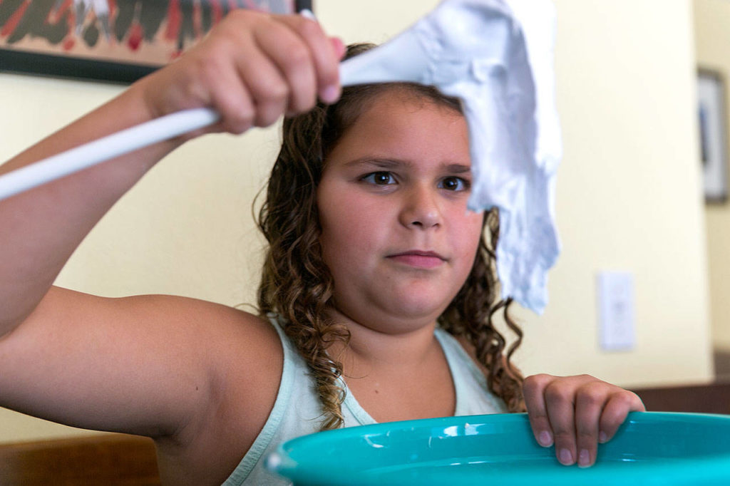 Amaya Hernandez, 10, mixes a solution to make slime at her home in Marysville. (Kevin Clark / The Herald)

