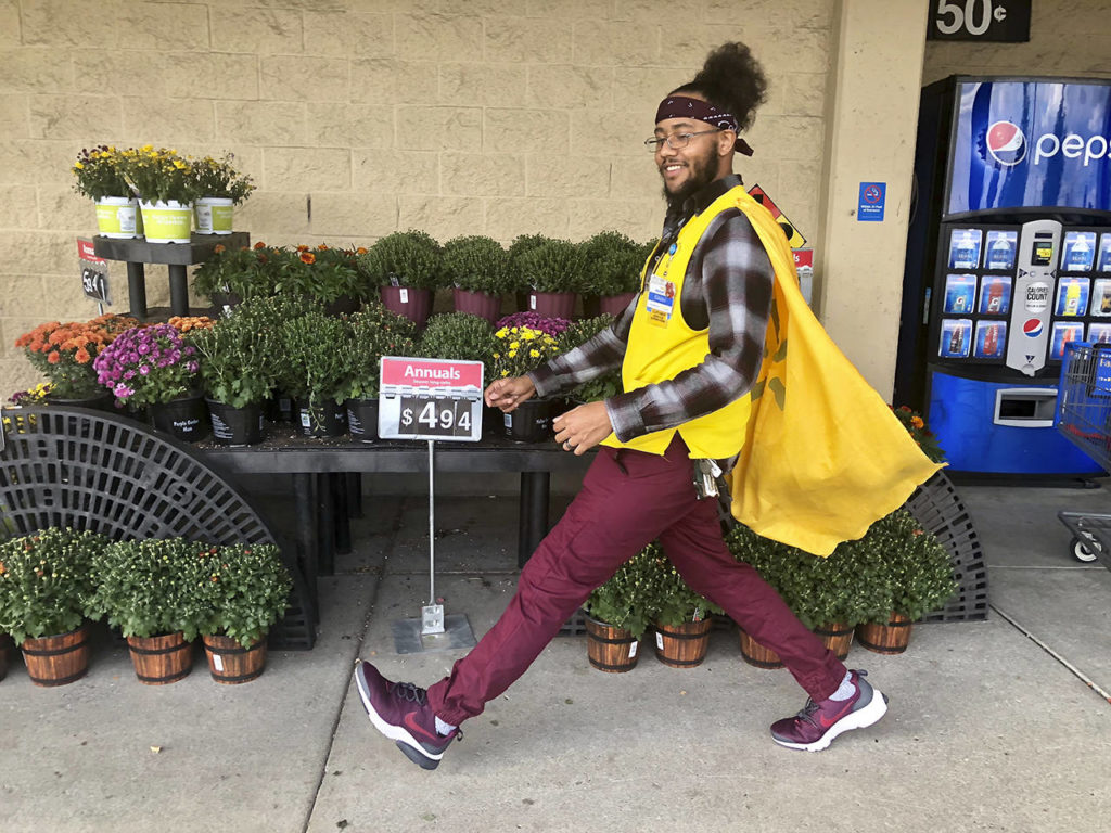 Isaiah Owens strolls past some plants at Walmart in his cape. Shoppers call him Captain Walmart, SuperWalmartman and other superhero names. (Andrea Brown / The Herald)
