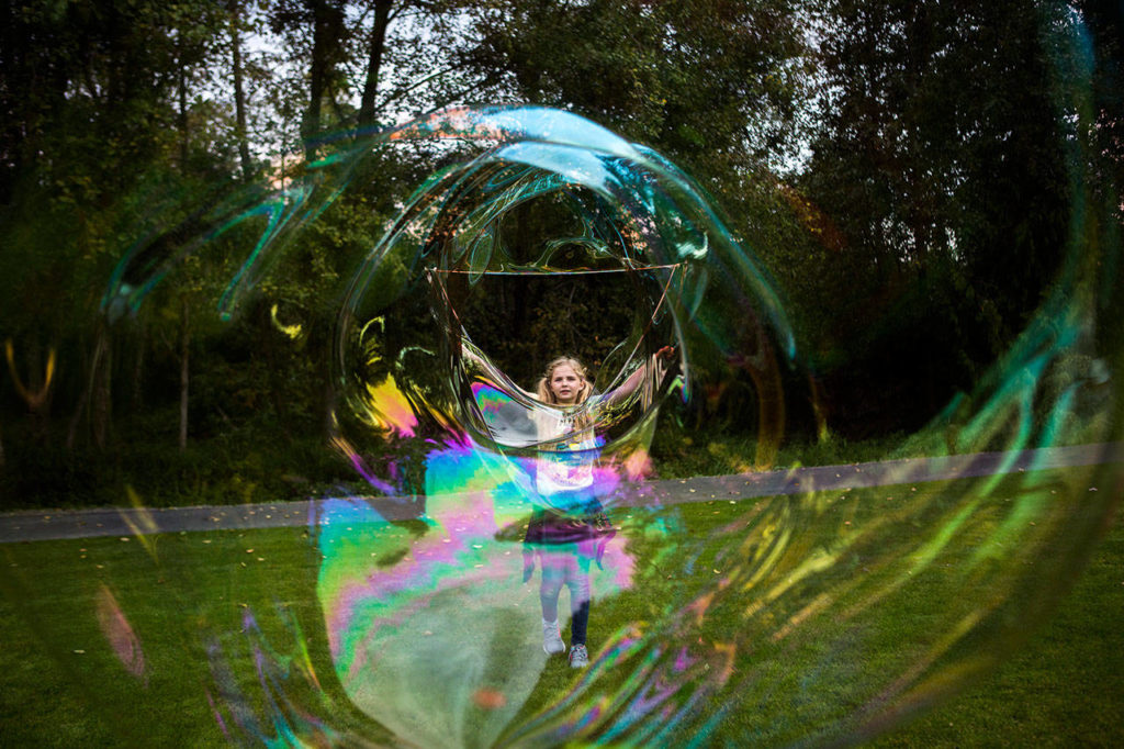 Tesila Hansen, 10, creates a large bubble during Lake Stevens Education Foundation Dolly Parton Imagination Library celebration on Sept. 21, 2018 in Lake Stevens, Wa. (Olivia Vanni / The Herald)
