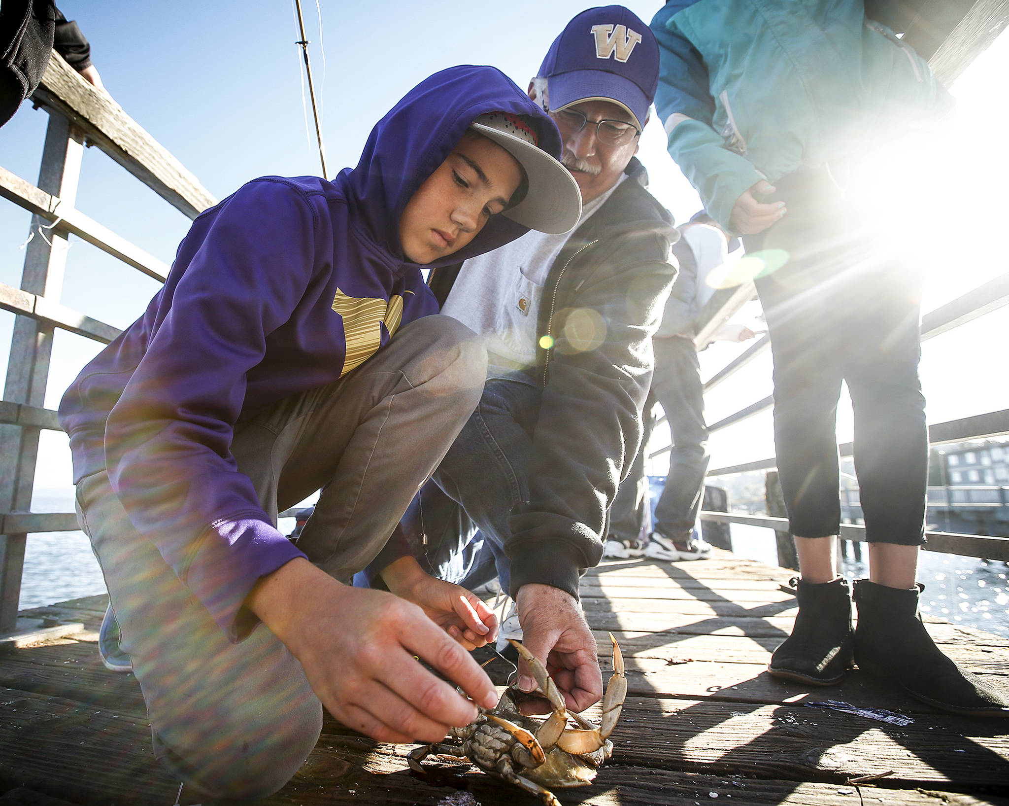 Noah Edwards (left), then 12, of Mukilteo, checks out a crab he caught with his grandfather, Steve Edwards, of Snohomish, during the 2016 fishing derby at the Mukilteo Lighthouse Festival. (Herald file)