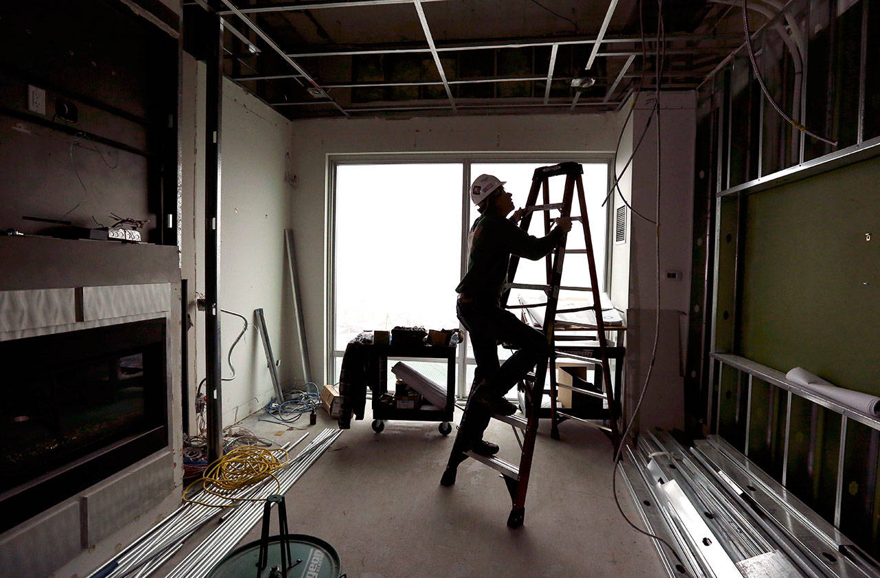 Electrician Todd Byfield climbs a ladder to install lighting in a room at the Tulalip Resort Casino in February, 2015, in Tulalip. The demand for skilled carpenters and electricians is expected to grow by 25 percent in the next 10 years, but not enough young adults have the skills necessary to begin apprenticeships. (Andy Bronson / Herald file photo)