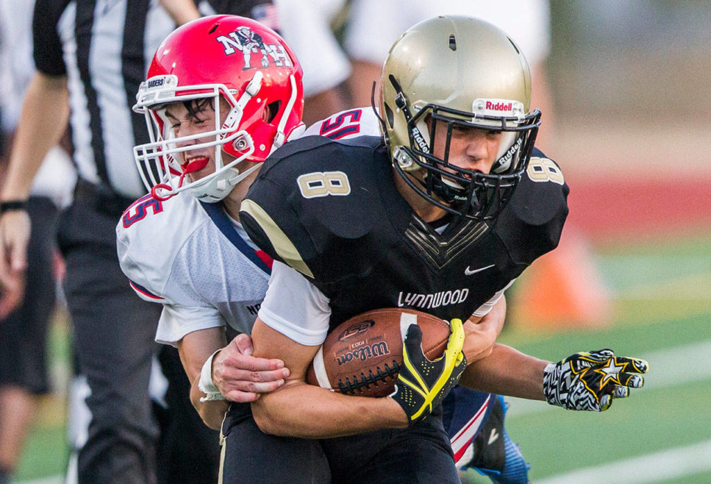 Lynnwood’s Tanner Fahey is tackled by Nathan Hale’s Chris Coon during Fridays game against Nathan Hale on Aug. 31, 2018 in Edmonds, Wa. (Olivia Vanni / The Herald)
