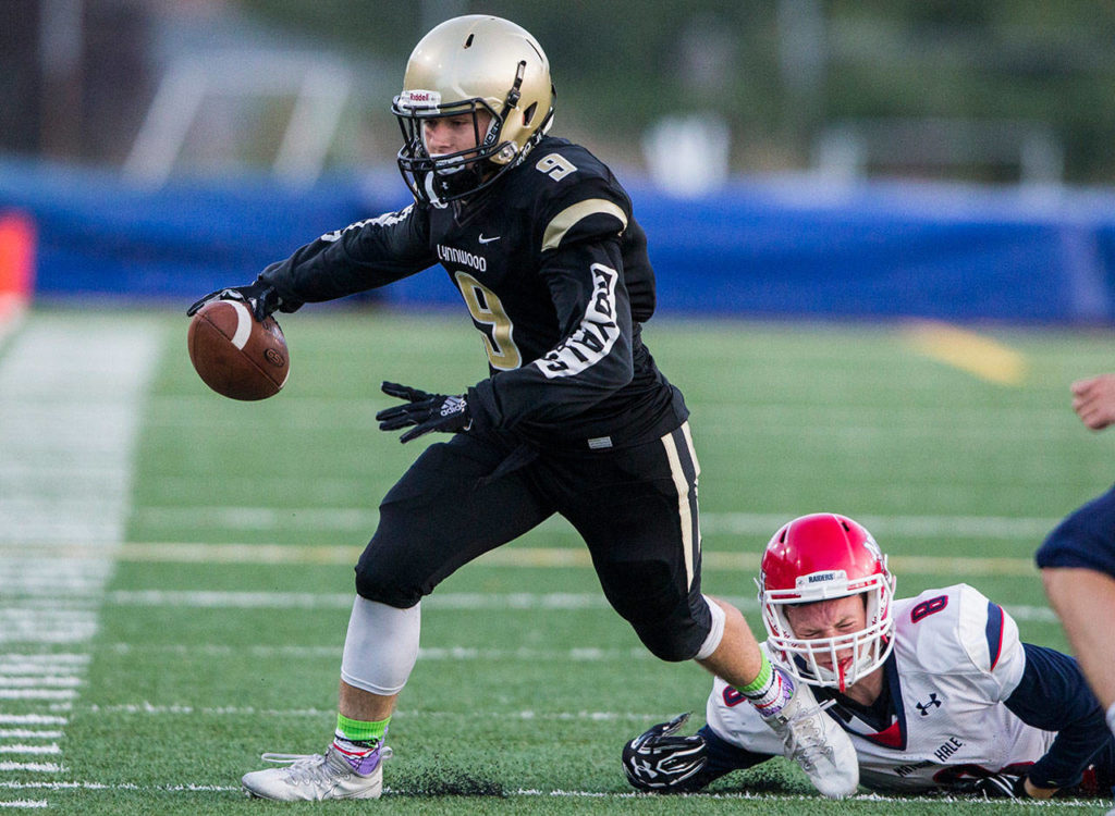Lynnwood’s Nate Killen escapes a tackle by Nathan Hale’s Pat McGough during Fridays game against Nathan Hale on Aug. 31, 2018 in Edmonds, Wa. (Olivia Vanni / The Herald)
