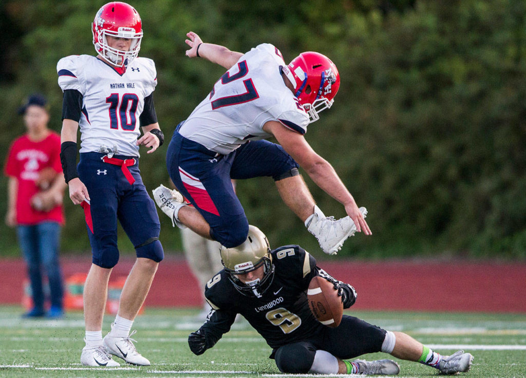 Lynnwood’s Nate Killen is jumped over by Nathan Hale’s Brandon Gibson during Fridays game against Nathan Hale on Aug. 31, 2018 in Edmonds, Wa. (Olivia Vanni / The Herald)
