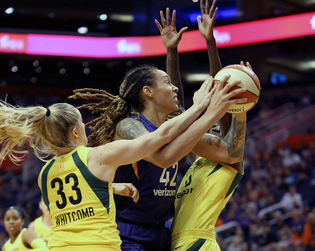 Phoenix Mercury center Brittney Griner (42) is guarded by Seattle Storm’s Sami Whitcomb (33) and Natasha Howard as she tries to drive to the basket during the first half of Game 4 of their WNBA semifinal series Sunday in Phoenix. (AP Photo/Ralph Freso)