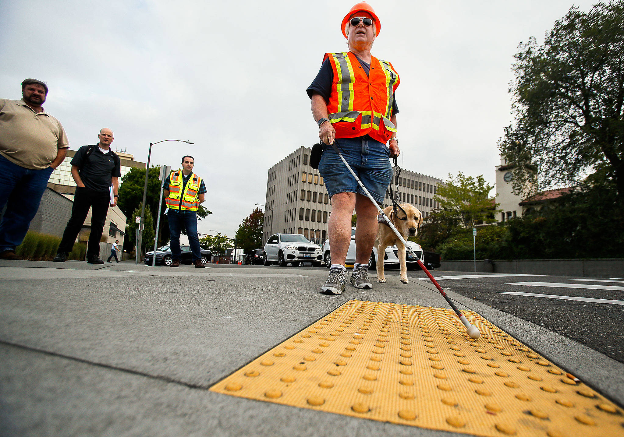 George Basioli, of Edmonds, who is blind, demonstrates the necessity of exact standards for sidewalks , curbs, crosswalks, bus stops and more, Friday in downtown Everett. (Dan Bates / The Herald)