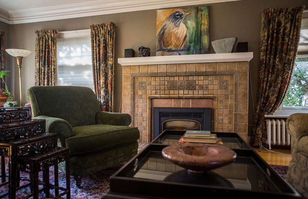 A Batchelder tile fireplace is the centerpiece of the living room at Marlies Egberding and Ritch Sorgen’s home Sept. 5, 2018 in Everett. (Olivia Vanni / The Herald)
