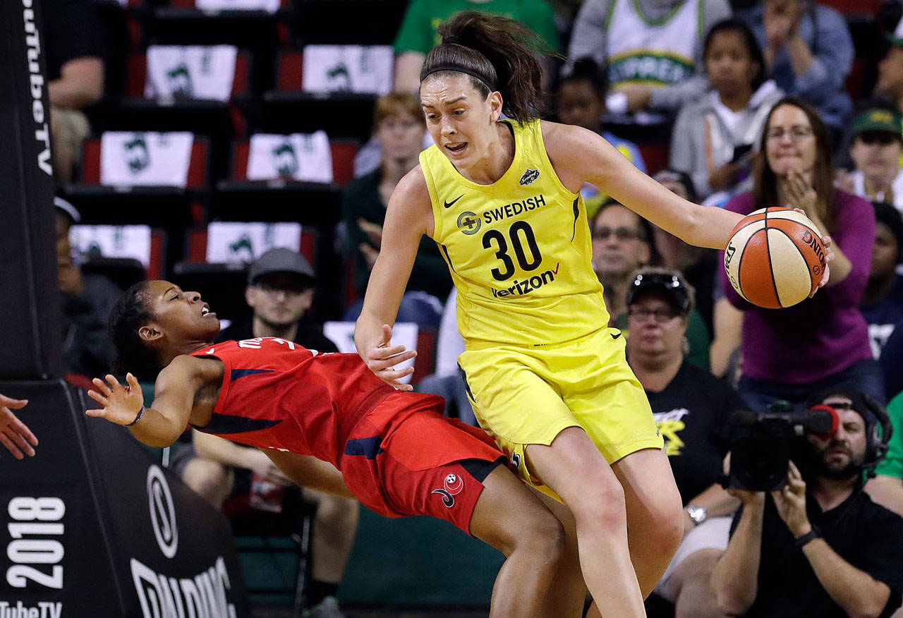 The Mystics’ Ariel Atkins (left) tumbles backward after fouling the Storm’s Breanna Stewart (30) during the first half of Game 1 of the WNBA Finals on Sept. 7, 2018, in Seattle. (AP Photo/Elaine Thompson)