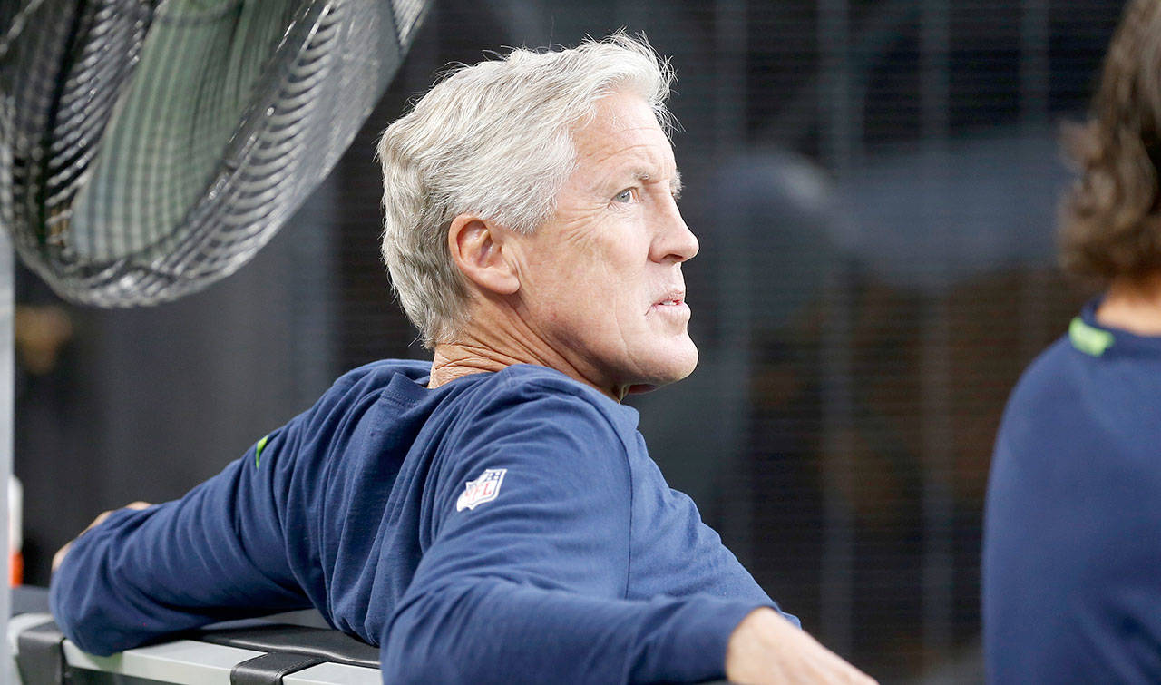 Seattle head coach Pete Carroll sits on the bench before an Aug. 24 preseason game in Minneapolis. Carroll said he “didn’t care” about an SI.com story that cited current and former players discussing dissension in the locker room. (AP Photo/Jim Mone)