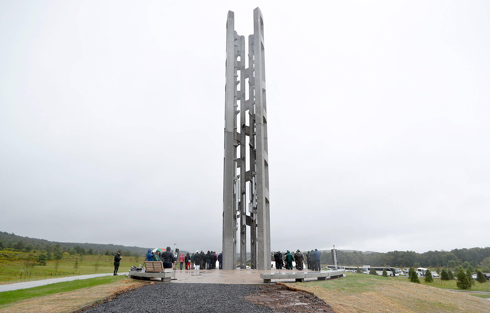 People attending the dedication stand around the 93-foot tall Tower of Voices on Sunday at the Flight 93 National Memorial in Shanksville, Pennsylvania. The tower contains 40 wind chimes representing the 40 people that perished in the crash of Flight 93 in the terrorist attacks of Sept. 11, 2001. (AP Photo/Keith Srakocic, Pool)