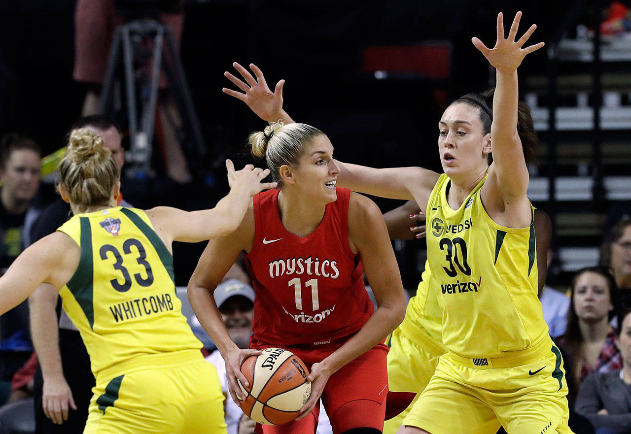 Washington’s Elena Delle Donne (11) looks for room to pass as Seattle’s Sami Whitcomb (33) and Breanna Stewart defend in the first half of Game 2 of the WNBA finals Sunday in Seattle. (AP Photo/Elaine Thompson)