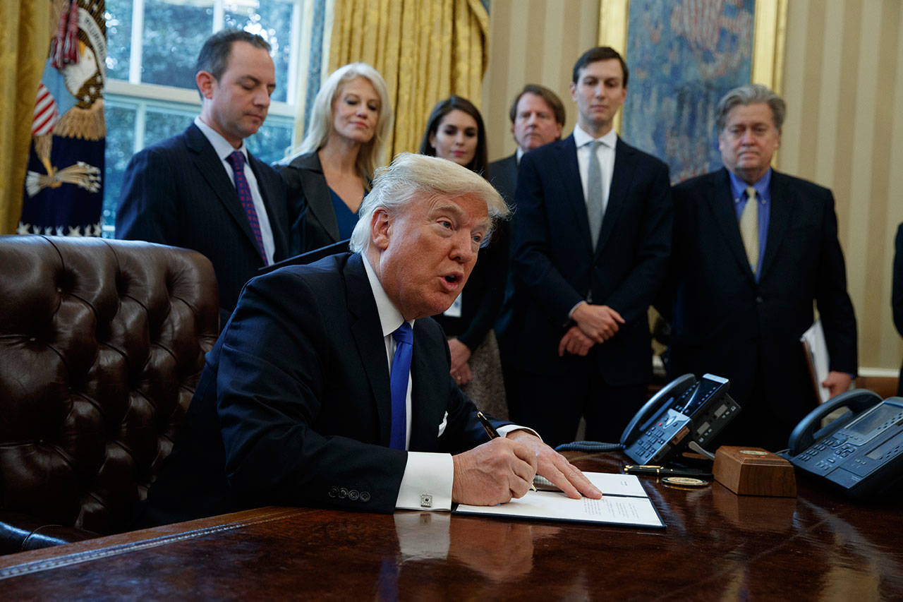 President Donald Trump signs an executive order on the Keystone XL pipeline in the Oval Office of the White House in Washington on Jan. 24, 2017. (AP Photo/Evan Vucci, File)