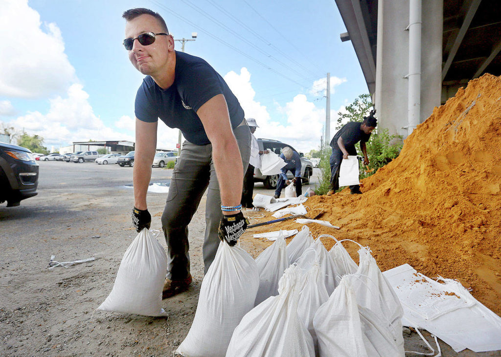 Kevin Orth loads sandbags into cars to prepare for Hurricane Florence on Monday in Charleston, South Carolina. (Grace Beahm Alford/The Post And Courier via AP) 
