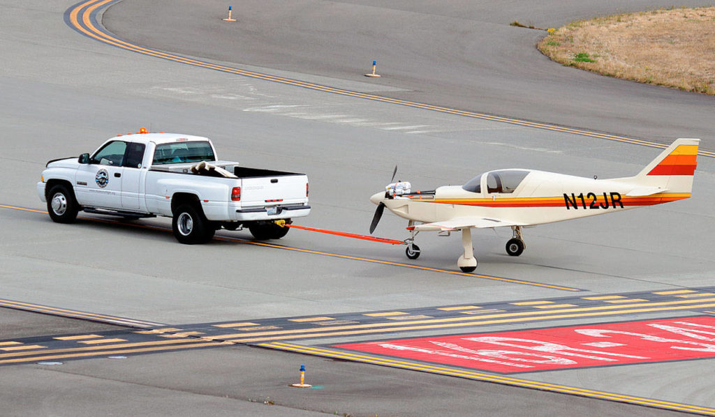 A Glasair III, which used to hang from the ceiling of the Aerospace Gallery at the Future of Flight Aviation Center in Mukilteo, is towed away at Paine Field this week as workers remove exhibits in preparation for the county-owned building’s new tenant, the Boeing Co. Two Glasair planes at the center were on loan from the Museum of Flight in Seattle. (Contributed photo)
