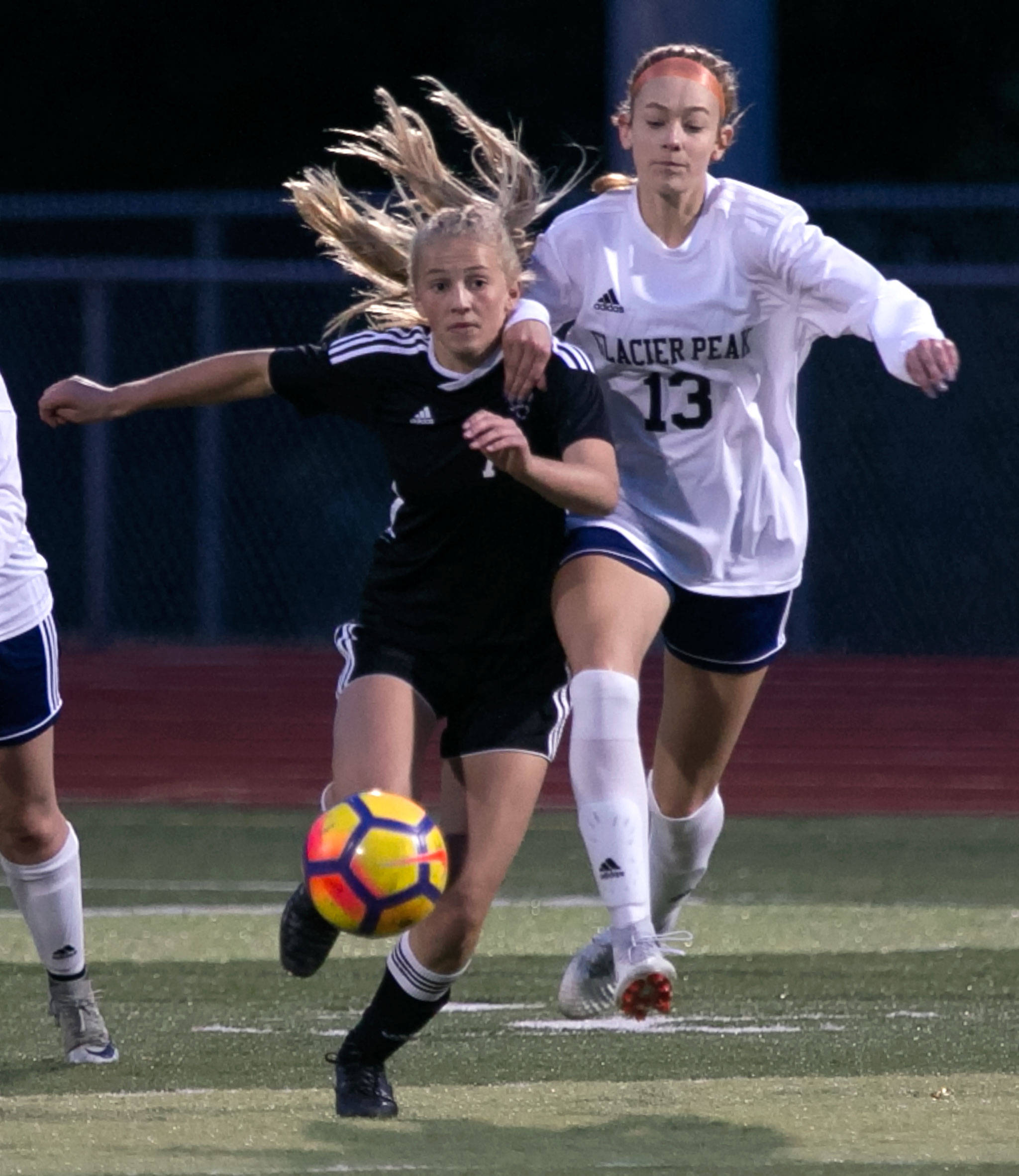 Lake Stevens’ Callaway Knutson (left) and Glacier Peak’s Emily Marriott vie for control of the ball during a Wesco 4A match Tuesday night in Lake Stevens. (Kevin Clark / The Herald)