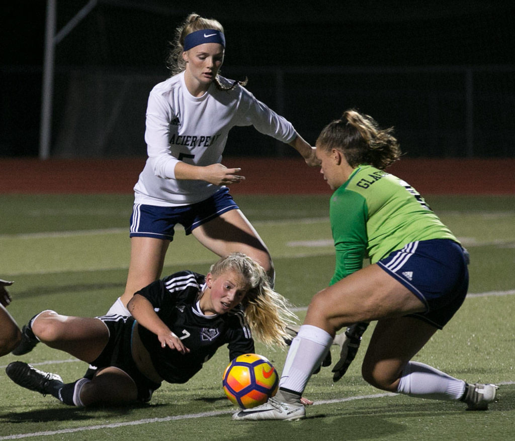 Lake Steven’s Callaway Knutson (bottom) charges toward goal as Glacier Peak goalkeeper Neomi MacMillan (right) and the Grizzlies’ Madison Seelhoff defend during Tuesday’s Wesco 4A match at Lake Stevens. (Kevin Clark / The Herald)

