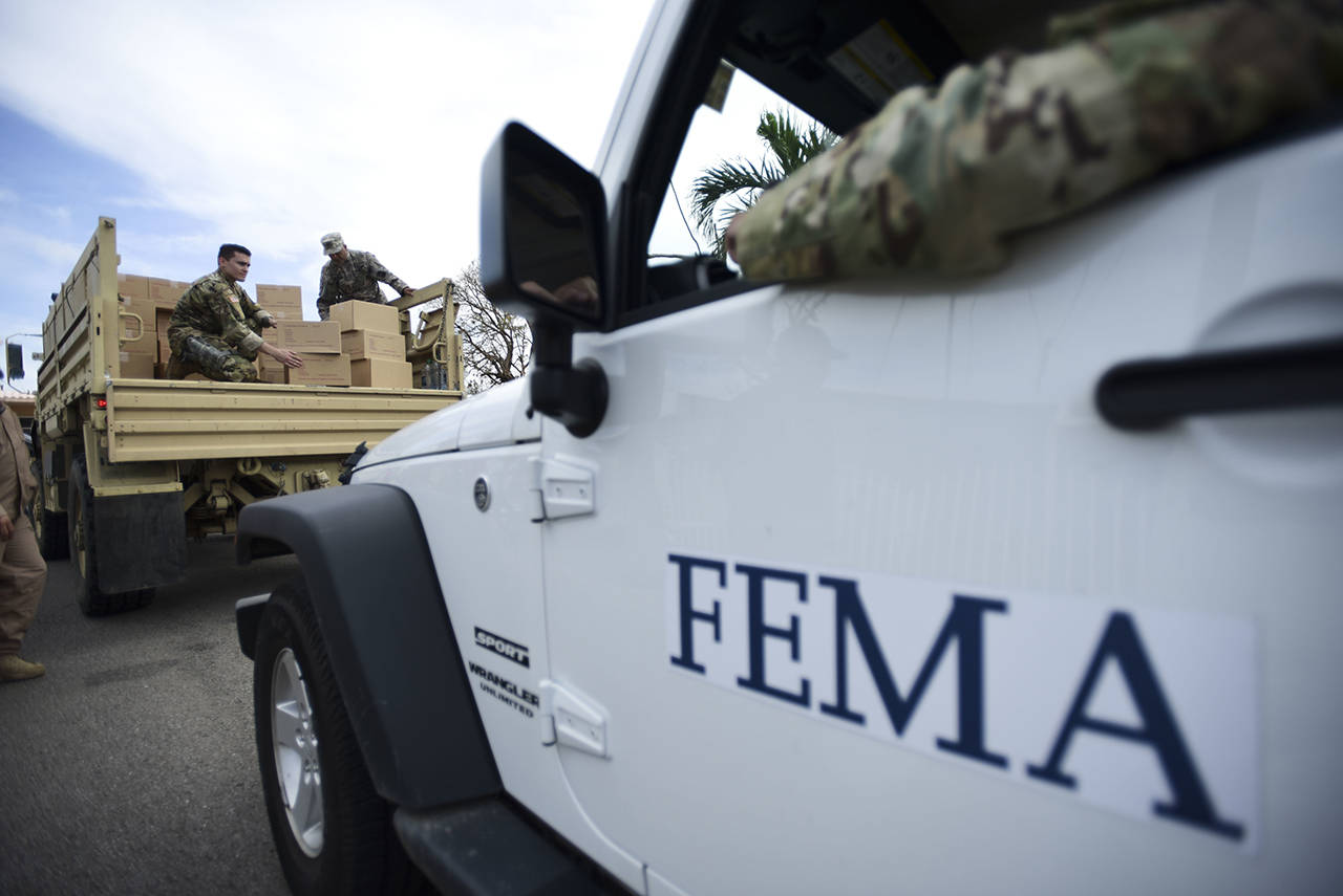 In this October 2017 photo, Department of Homeland Security personnel deliver supplies to Santa Ana community residents in the aftermath of Hurricane Maria in Guayama, Puerto Rico. (AP Photo/Carlos Giusti, File)