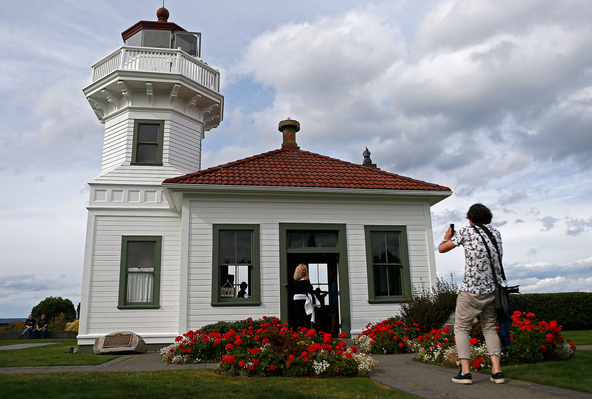 A couple takes a photo in front of the Mukilteo Lighthouse. The lighthouse, built in 1906, is one of the most iconic landmarks in all of Snohomish County. (Olivia Vanni / The Herald)