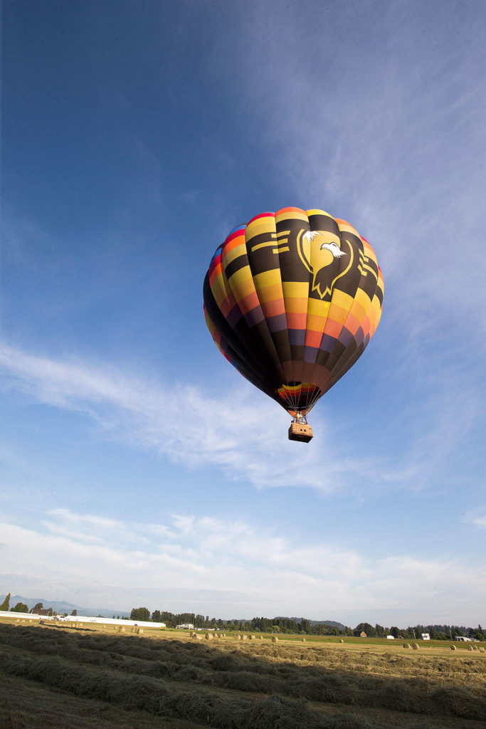 Taking off from Harvey Airfield, pilot Jay Woodward, owner of Balloon Depot, hosts riders on a hot air balloon trip over the Snohomish Valley. (Andy Bronson / The Herald)
