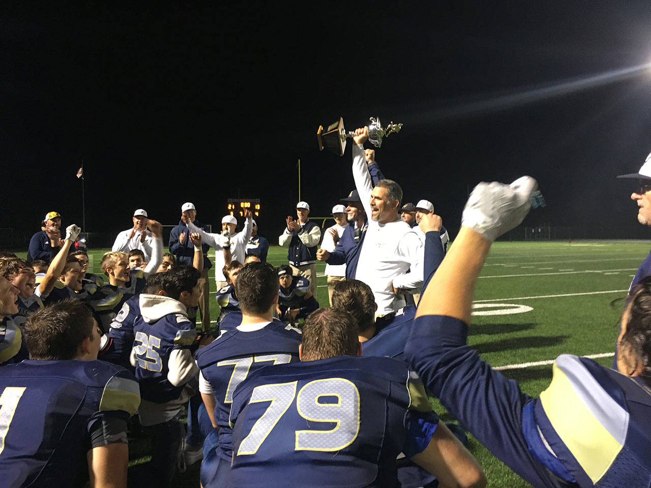 Arlington coach Greg Dailer hoists the Still Cup after a 21-13 win over Stanwood on Sept. 14, 2018, in Arlington. (Nick Patterson photo)