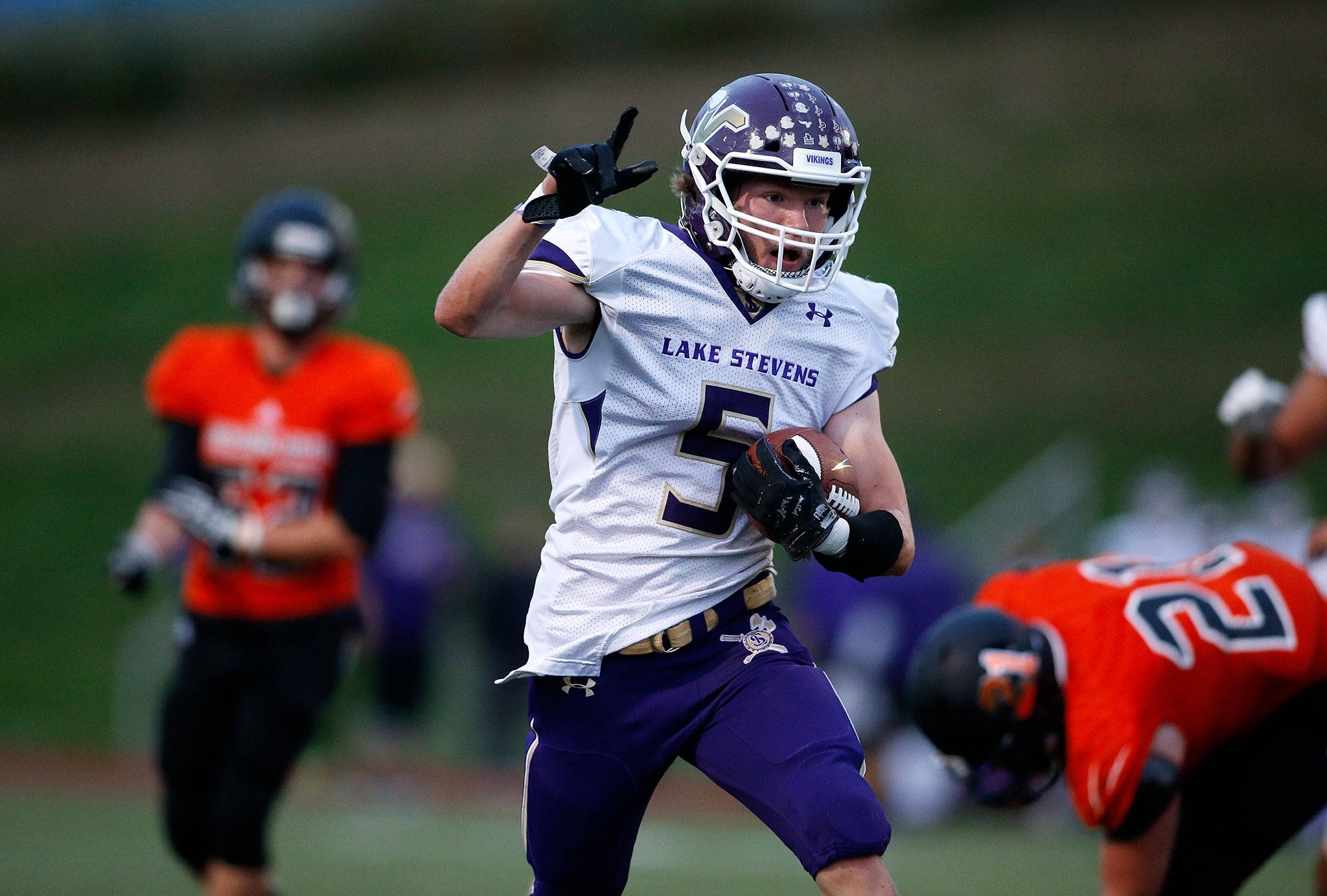 Lake Stevens’ Ian Hanson raises a finger while running for a touchdown in Lake Stevens’ 49-31 victory over Monroe on Friday night. (Andy Bronson / The Herald)