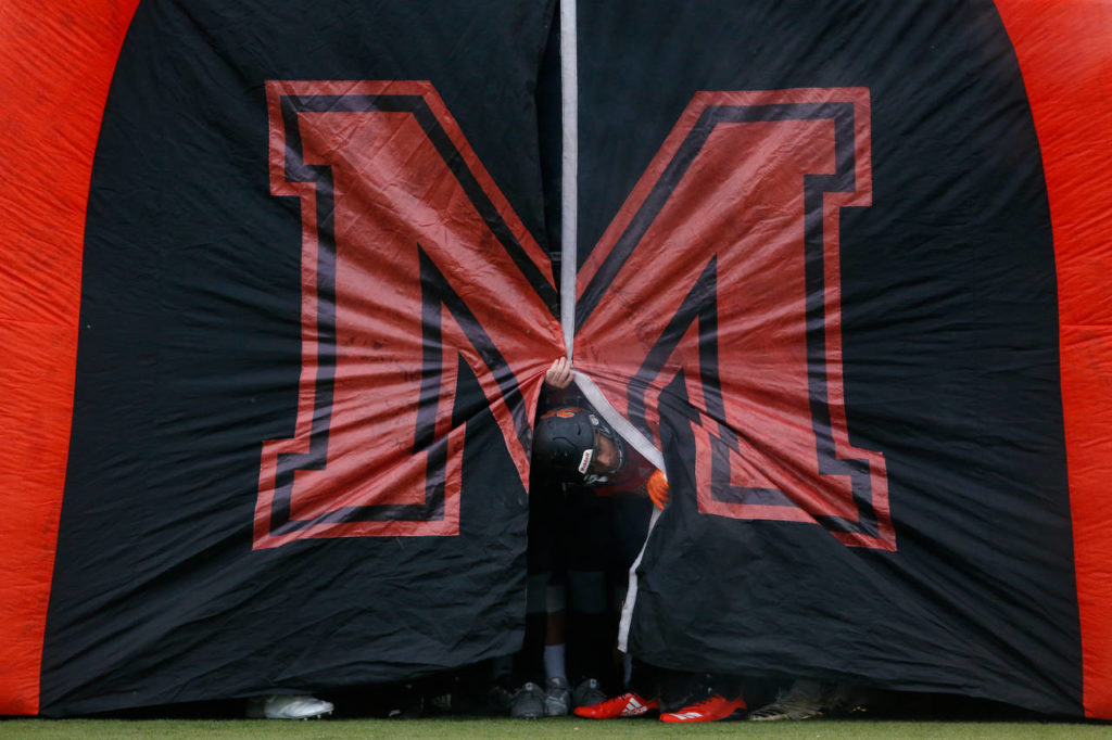 A Monroe player looks out from inside an inflatable tunnel before the Lake Stevens-Monroe football game Friday night. (Andy Bronson / The Herald)
