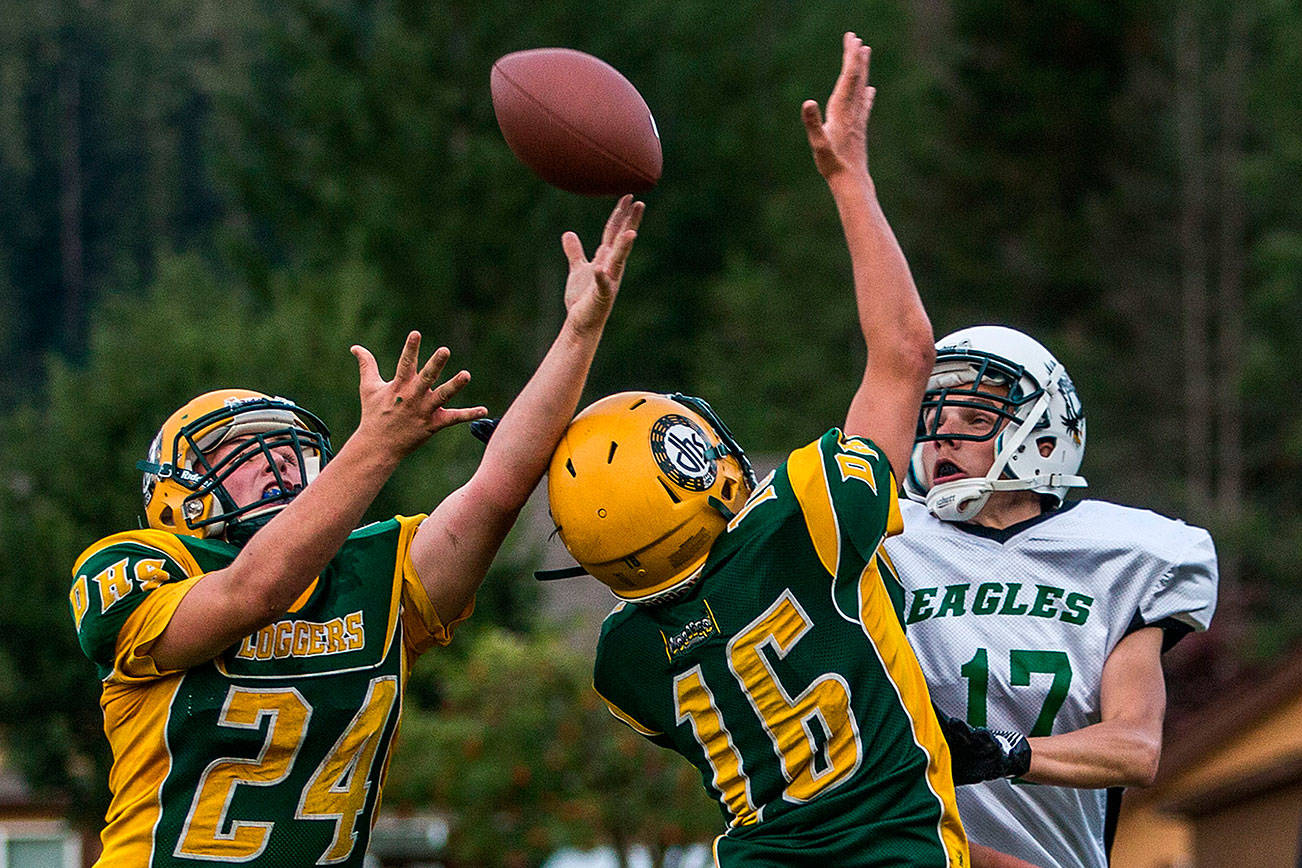 Darrington’s Leevi Whittaker and Ashton Weidman reach for a pass Friday in Darrington. (Olivia Vanni / The Herald)