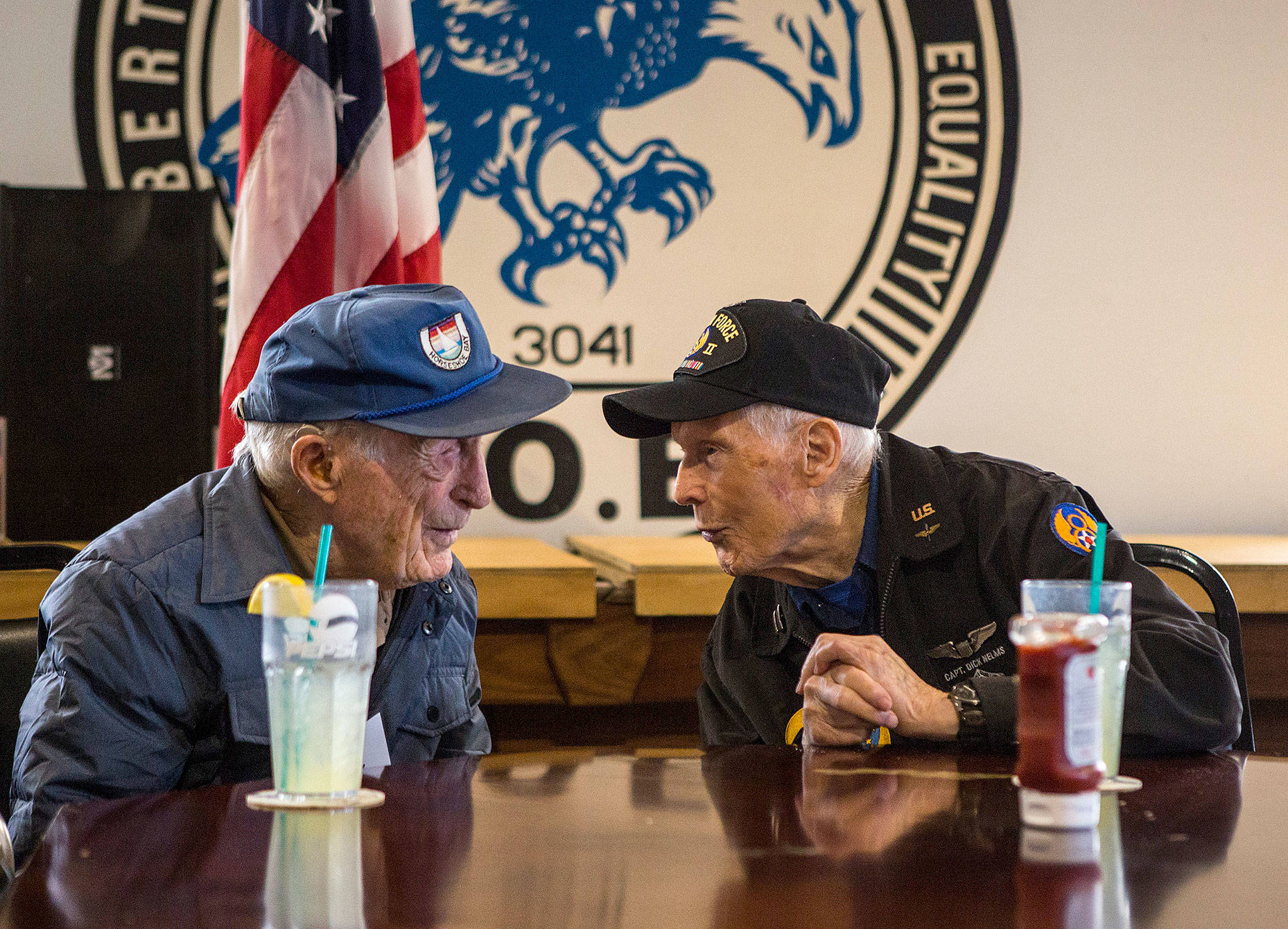 World War II veterans Buck Weaver, 100 (left), and Dick Nelms, 95, meet each other Thursday and chat for the first time at the Stanwood Fraternal Order of Eagles. (Olivia Vanni / The Herald)