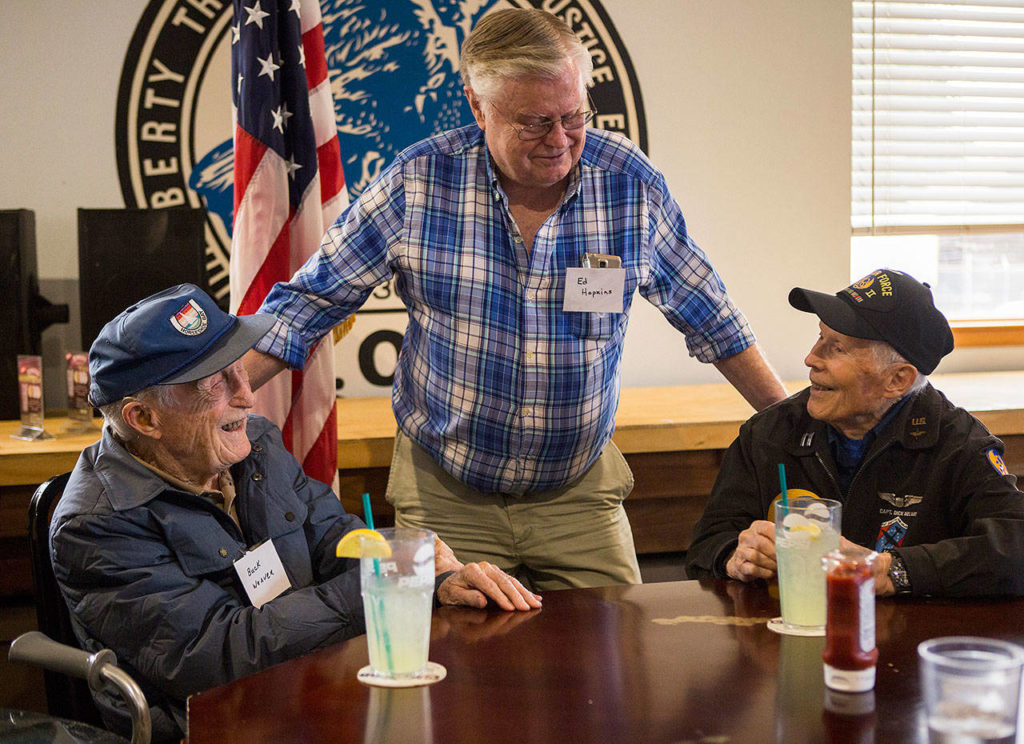 World War II veterans Buck Weaver, 100 (left), and Dick Nelms, 95 (right) chat with Ed Hopkins on Thursday at the Stanwood Fraternal Order of Eagles. (Olivia Vanni / The Herald)

