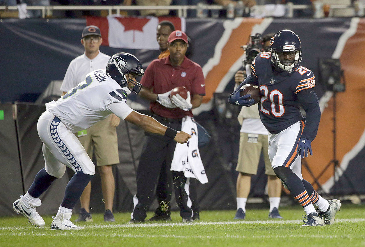Chicago’s Prince Amukamara (20) runs away from Seattle’s Russell Wilson (3) after intercepting a pass and returning it for a touchdown in the fourth quarter of the Seahawks’ 24-17 loss to the Bears on Monday in Chicago. (AP Photo/David Banks)