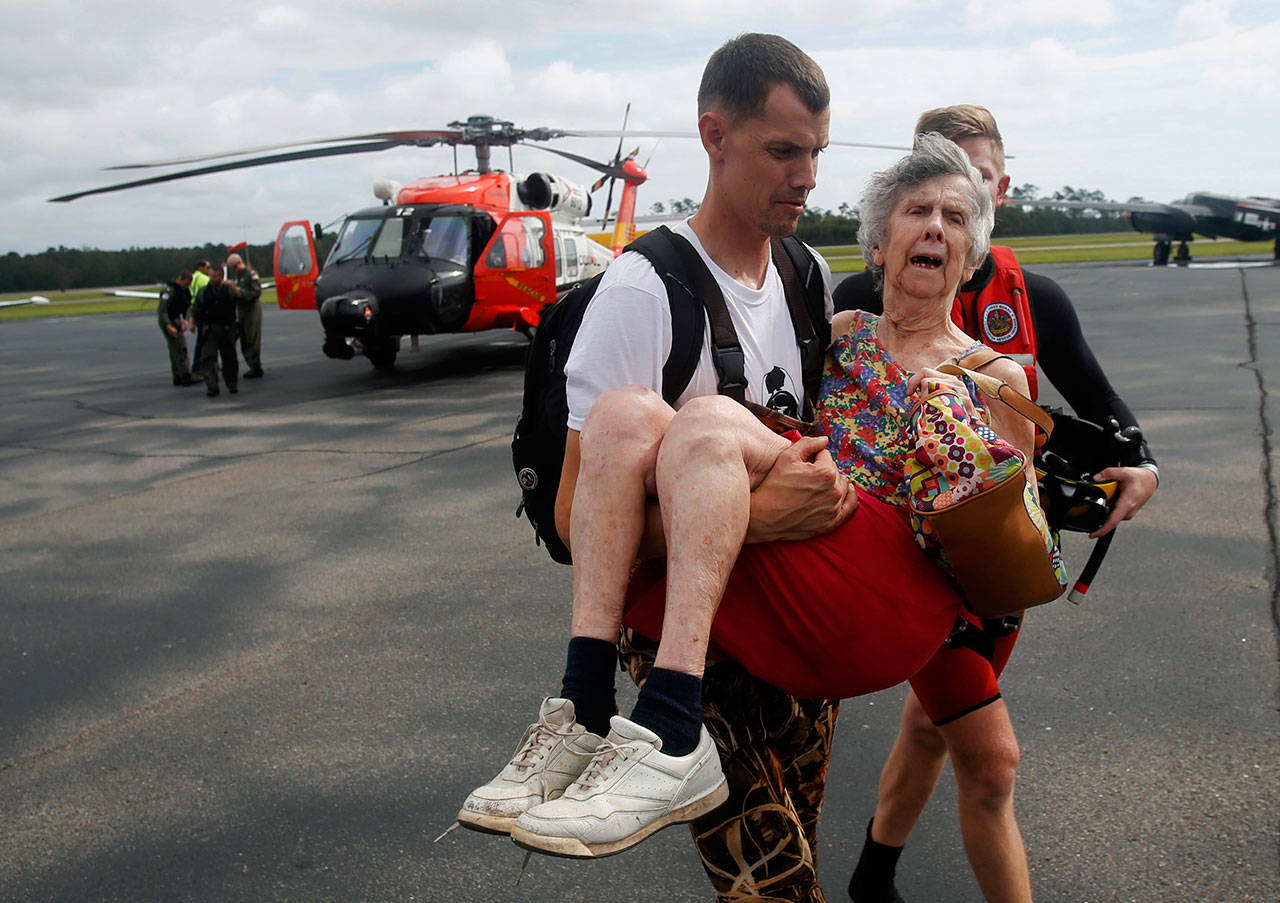 An unidentified family member carries Ruth Brady to safety at the Wilmington airport in Wilmington, North Carolina, on Monday. (Steve Helber / Associated Press)