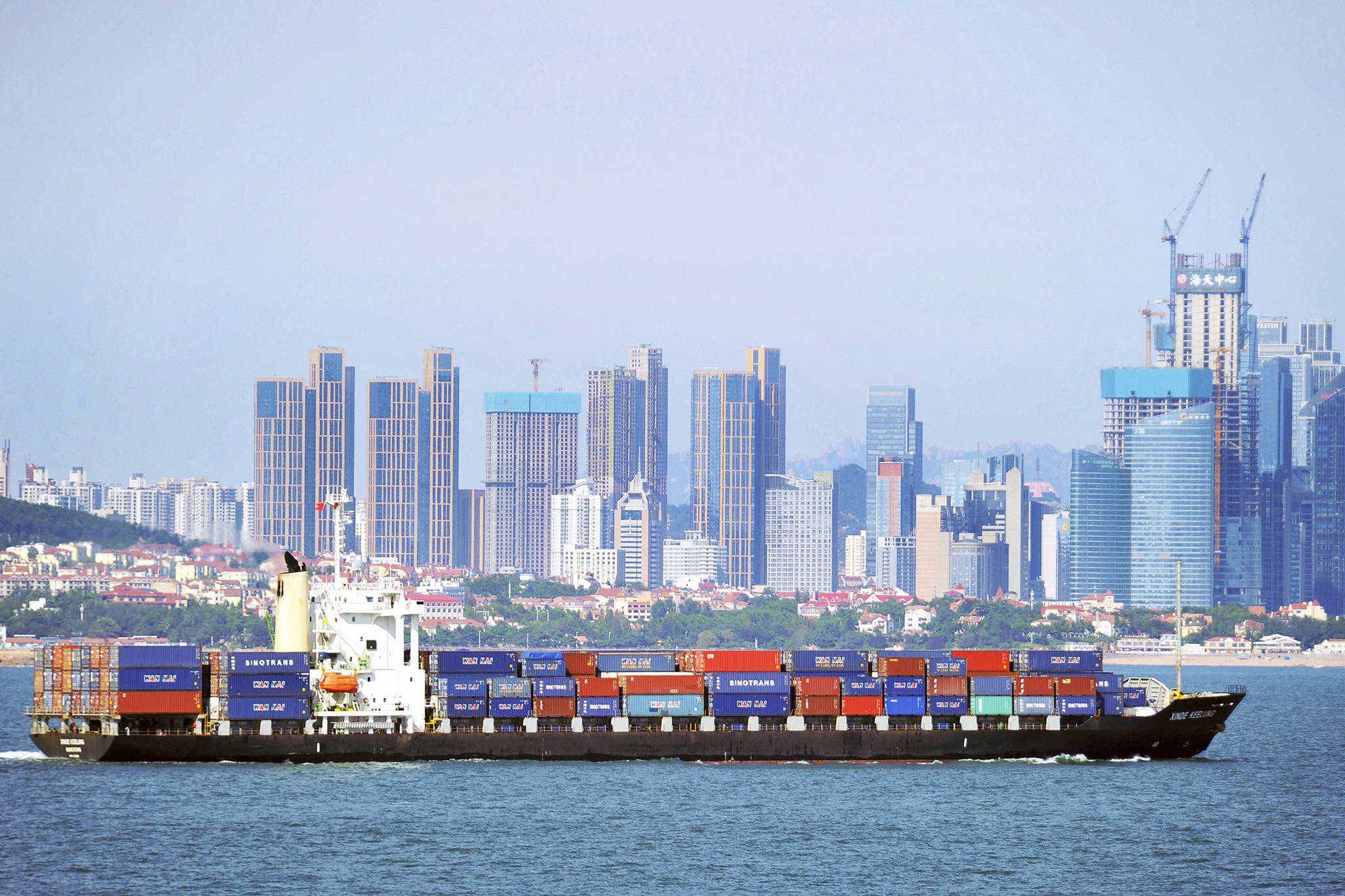 A container ship sails past the city skyline of Qingdao in eastern China’s Shandong province on Sept. 13. The Trump administration announced Monday that it will impose tariffs on $200 billion more in Chinese goods starting next week, escalating a trade war between the world’s two biggest economies and potentially raising prices on goods ranging from handbags to bicycle tires. (Chinatopix via AP)