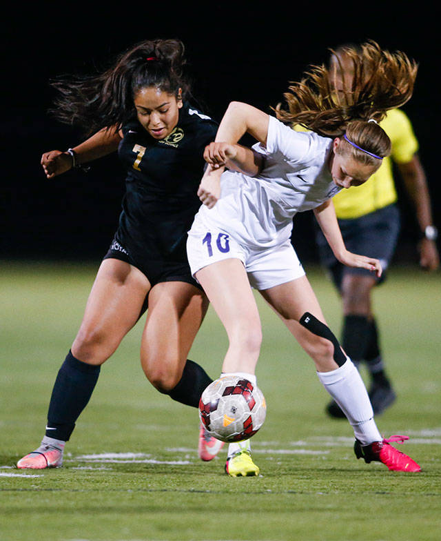 Lynnwood’s Anna Hernandez (left) battles with Oak Harbor’s Danielle Lonborg for control of the ball Tuesday during a Wesco 3A match in Lynnwood. The Royals won 2-1. (Andy Bronson / The Herald)