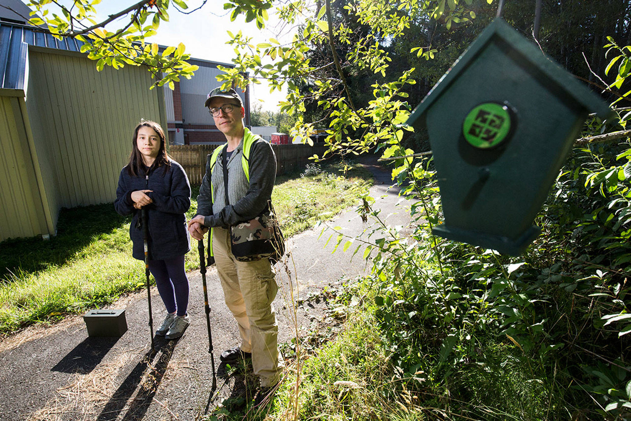 Rich Schliefer and daughter Hinako at one of the new geocache sites put up by the City of Mill Creek on Tuesday, Sept. 18, 2018 in Mill Creek, Wa. (Andy Bronson / The Herald)