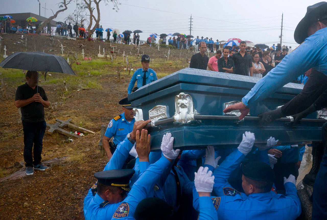 Police lift the coffin of fellow officer Luis Angel Gonzalez, during his funeral at the cemetery in Aguada, Puerto Rico on Sept. 29, 2017. Gonzalez died when he tried to navigate a river crossing in his car during the passing of Hurricane Maria. (Ramon Espinosa / Associated Press file photo)