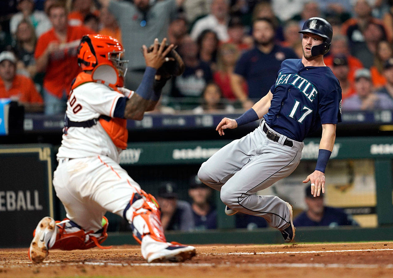 The Mariners’ Mitch Haniger (17) scores as Astros catcher Martin Maldonado attempts apply the tag during the fifth inning of a game on Sept. 19, 2018, in Houston. (AP Photo/David J. Phillip)