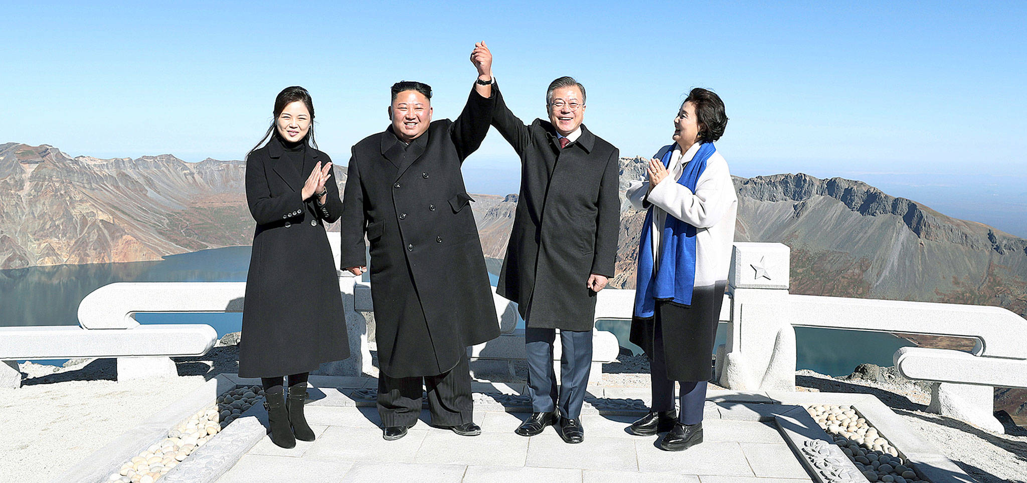 South Korean President Moon Jae-in (second from right) and his wife, Kim Jung-sook (right), stand with North Korean leader Kim Jong Un (second from left) and his wife, Ri Sol Ju, on Mount Paektu in North Korea on Thursday. (Pyongyang Press Corps Pool via AP)