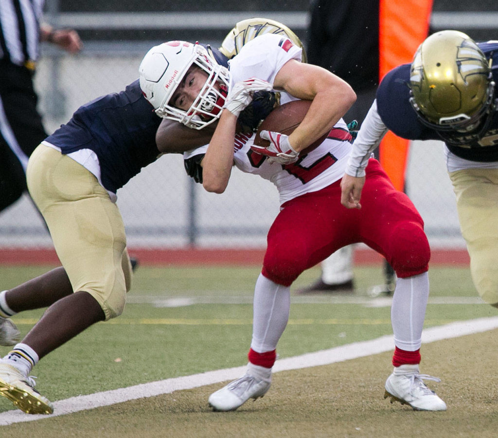 Snohomish’s Tyler Massena (center) crosses the goal line with Everett’s Jeremy Reed attempting a stop during a game on Sept. 21, 2018, at Everett Memorial Stadium. (Kevin Clark / The Herald)

