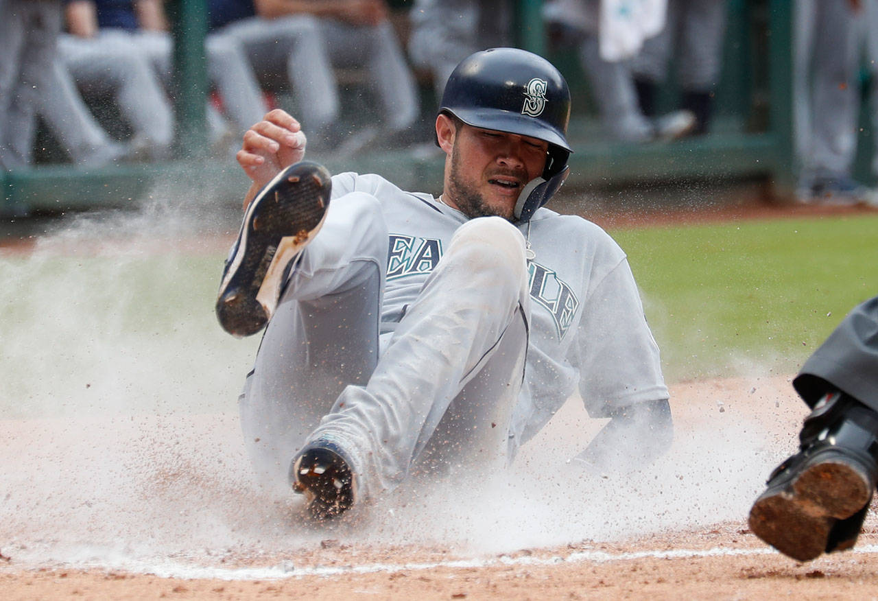 Seattle’s Kristopher Negron slides across home plate on a double by Guillermo Heredia during the third inning of Sunday’s game in Arlington, Texas. (AP Photo/Jim Cowsert)