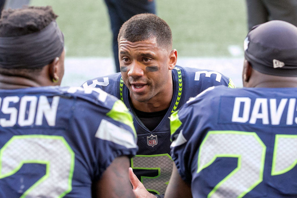 Seahawks Russell Wilson talks with running backs Chris Carson (left) and Mike Davis Sunday afternoon at CenturyLink Field in Seattle on September 23, 2018. Seahawks won 24-13. (Kevin Clark / The Herald)
