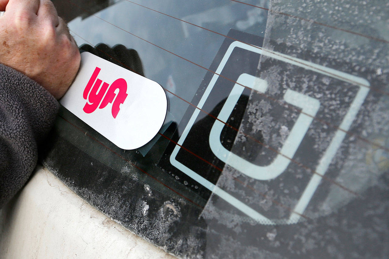 A Lyft logo is installed on a Lyft driver’s car next to an Uber sticker in Pittsburgh. The “gig” economy might not be the new frontier for America’s workforce after all. The evidence is growing that over time, task-oriented work offered by online apps doesn’t deliver the financial returns many expect. (Gene J. Puskar / AP file)
