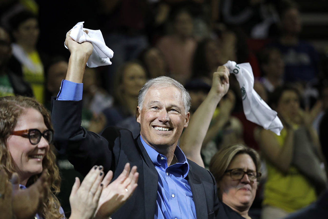 Gov. Jay Inslee waves a towel as he is introduced to fans during a break in Game 1 of the WNBA basketball finals between the Seattle Storm and the Washington Mystics on Sept. 7 in Seattle. (AP Photo/Elaine Thompson, file)