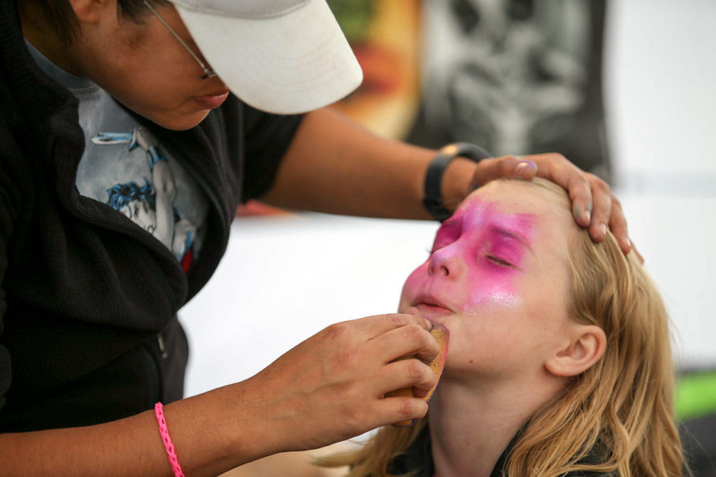Lily Ruyz (left) paints Mimi Cormier’s face at last year’s Everett Sausage Fest. (Kevin Clark / Herald file)

