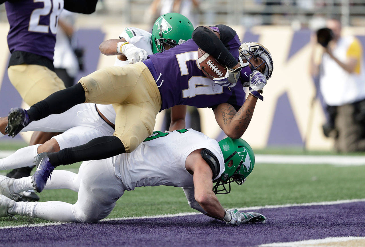 Washington’s Kamari Pleasant (24) dives into the end zone for a touchdown against North Dakota on Sept. 8, 2018, in Seattle. (AP Photo/Elaine Thompson)