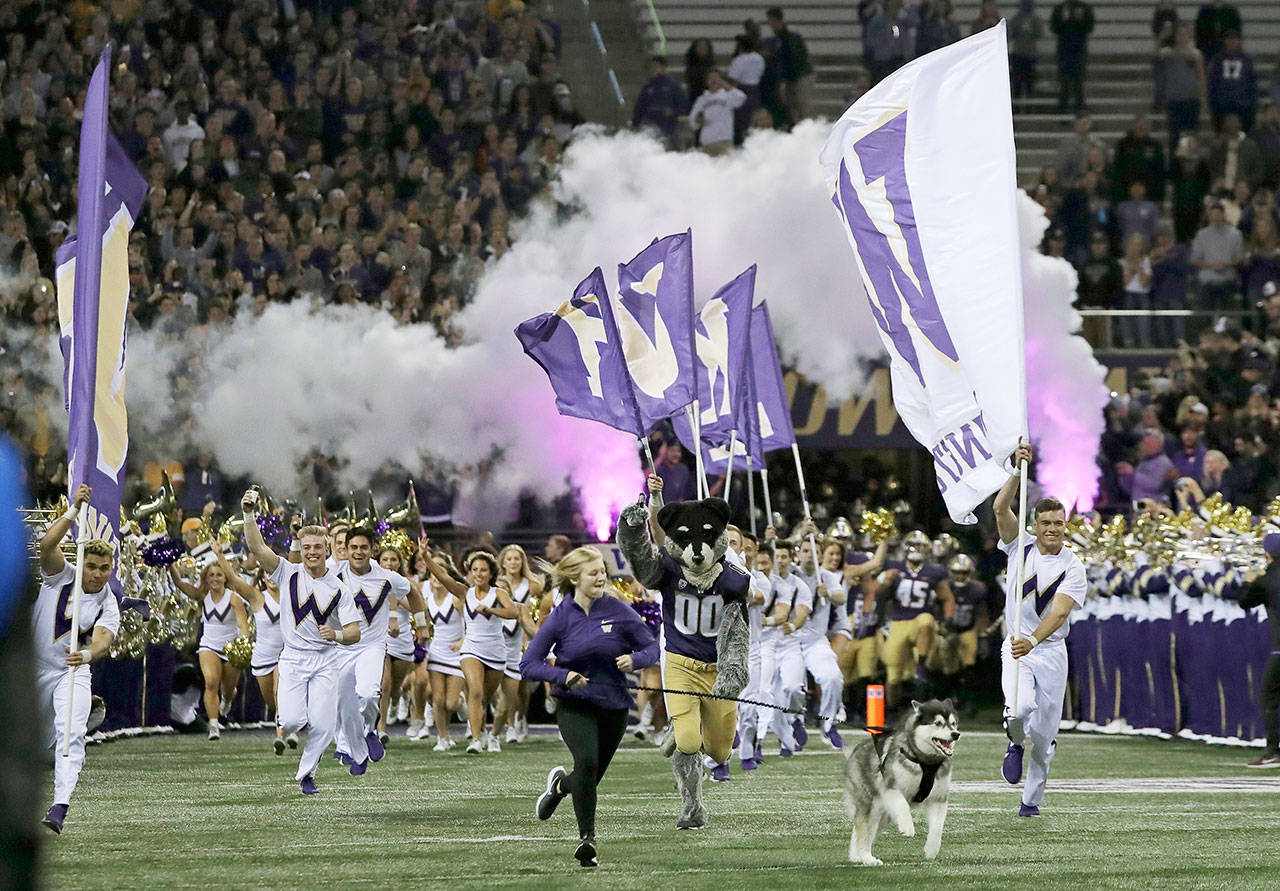 Dubs II, the Washington Huskies’ mascot, leads the team out of the tunnel for its game against Arizona State last Saturday night in Seattle. (AP Photo/Ted S. Warren)
