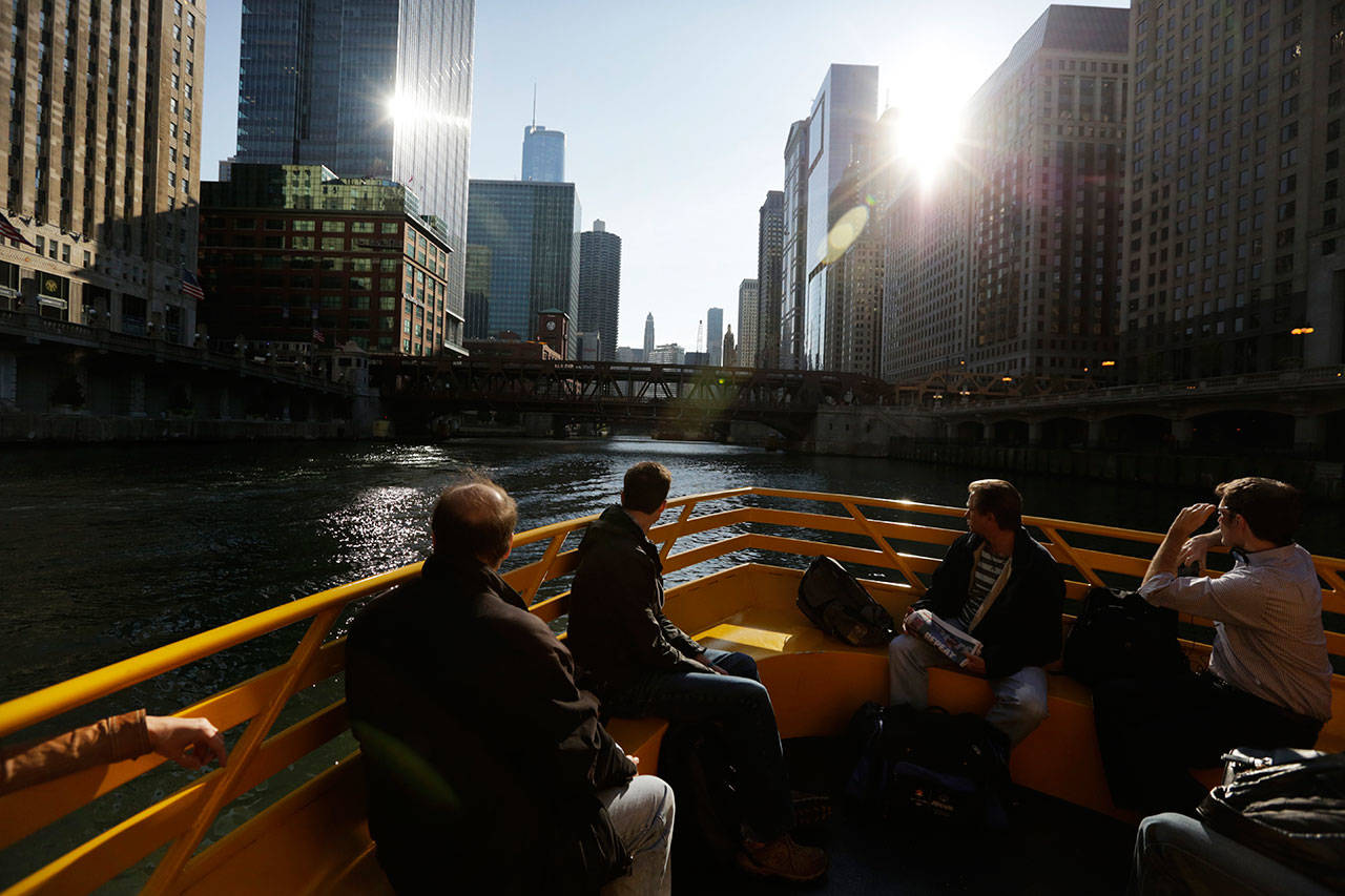 Morning commuters ride a water taxi up the Chicago River to Michigan Avenue in Chicago. No matter your age, what the Federal Reserve does to interest rates will most likely affect you. (M. Spencer Green / AP file)