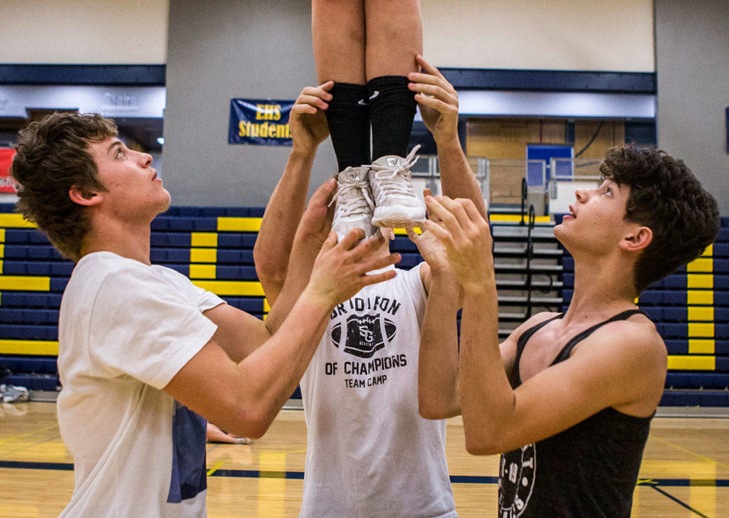 Cody Bennett (left) and Judah Nanto (right) help pop off during rehearsal in the Everett High School gym on Sept. 26. (Olivia Vanni / The Herald)

