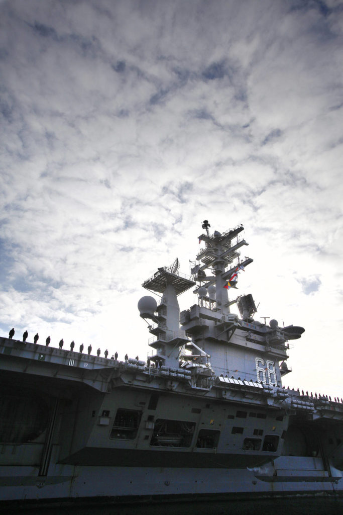 USS Nimitz personnel line the deck of the aircraft carrier as it entered the Port of Everett on Dec. 16, 2013. (Genna Martin / Herald file)
