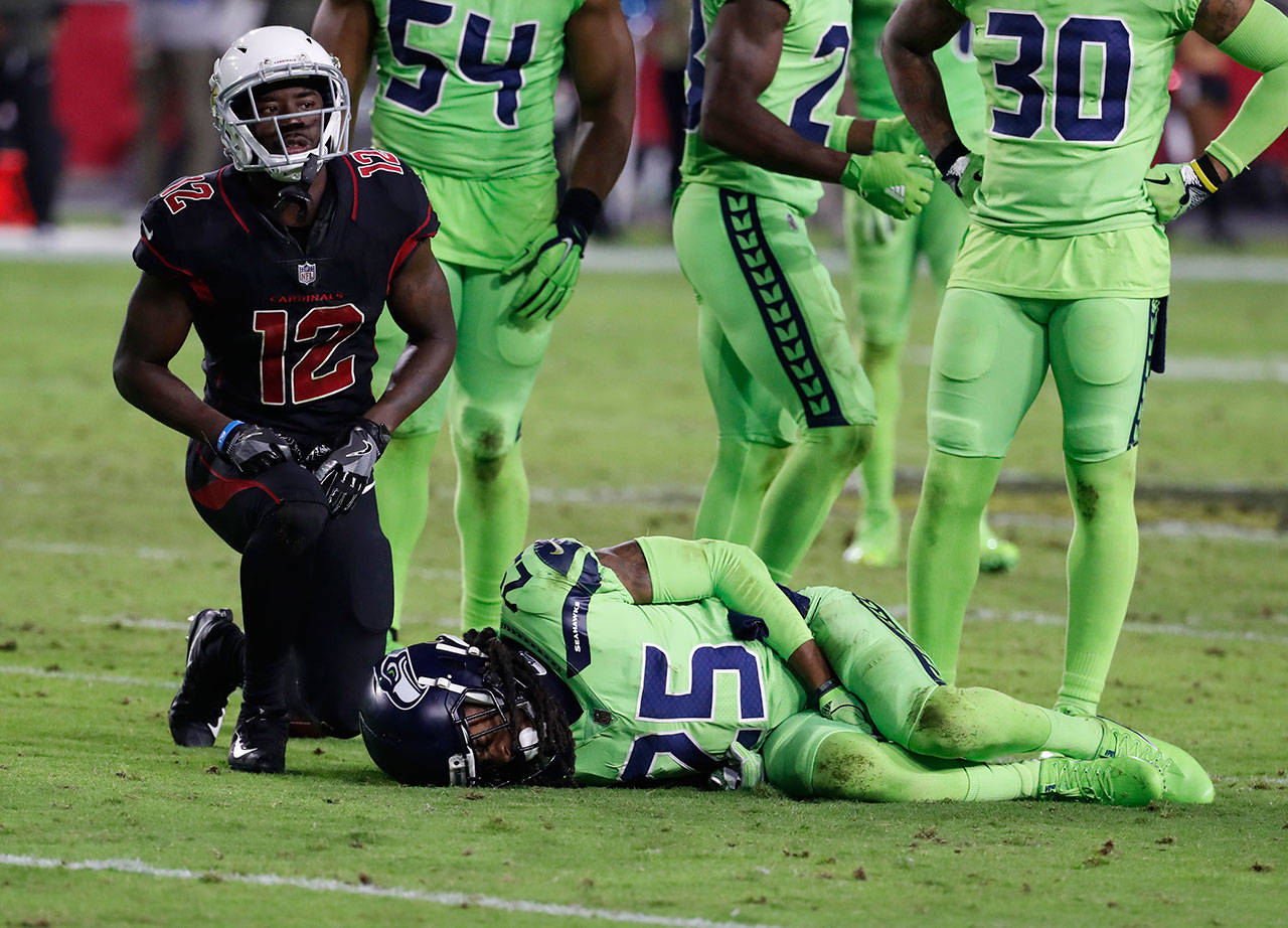 Seahawks cornerback Richard Sherman (25) lies on the turf hurt after tackling Cardinals wide receiver John Brown (12) during the second half of a game Nov. 9, 2017, in Glendale, Ariz. (AP Photo/Rick Scuteri)